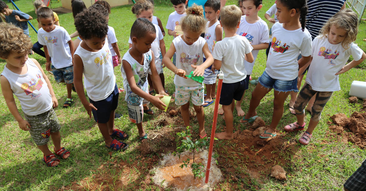 Children gathered around a newly planted tree as part of Fruit Tree 101's innovative education program to create orchards in schoolyards