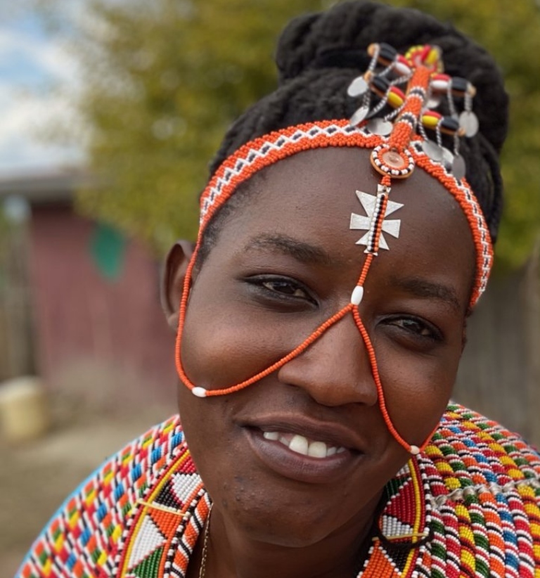 A woman wearing colorful beaded jewelry on her face and around her neck