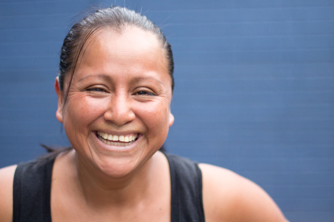 A woman smiling against a blue background