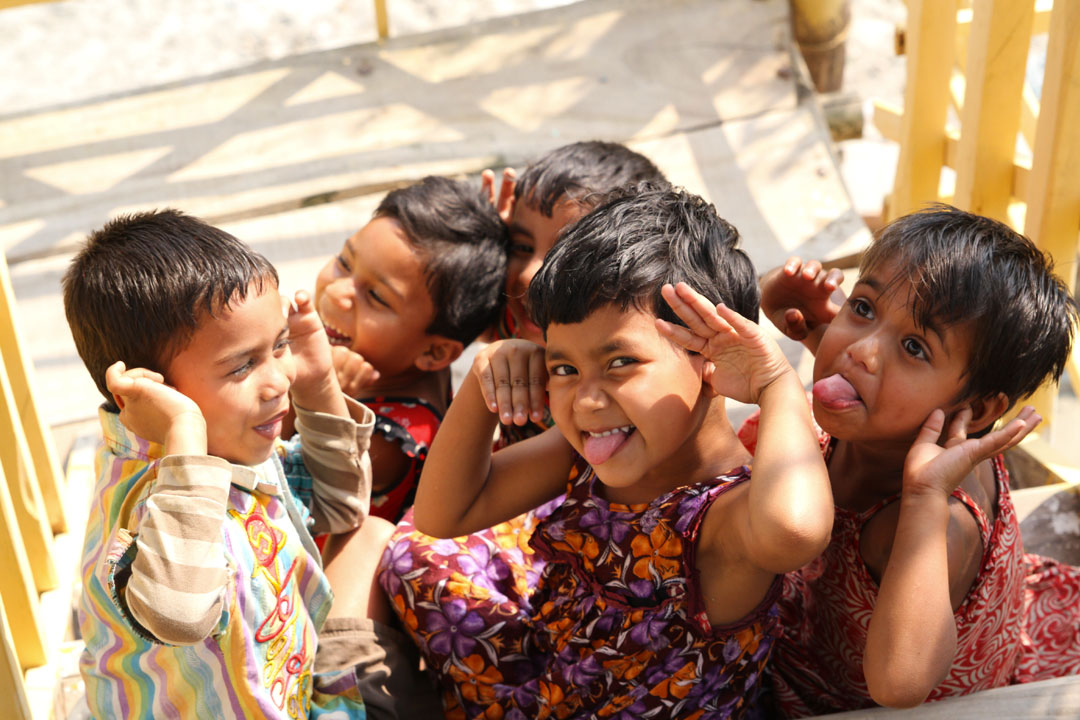 A group of children smile and make funny faces