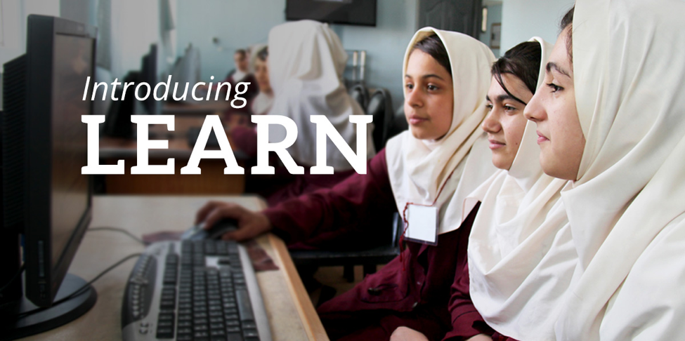 Three young women look at a computer