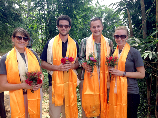 four people with flowers and orange scarves