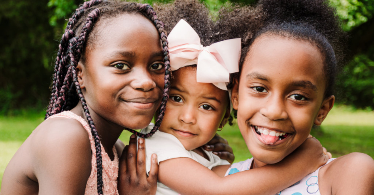 Three young women lean in and smile at the camera girl power