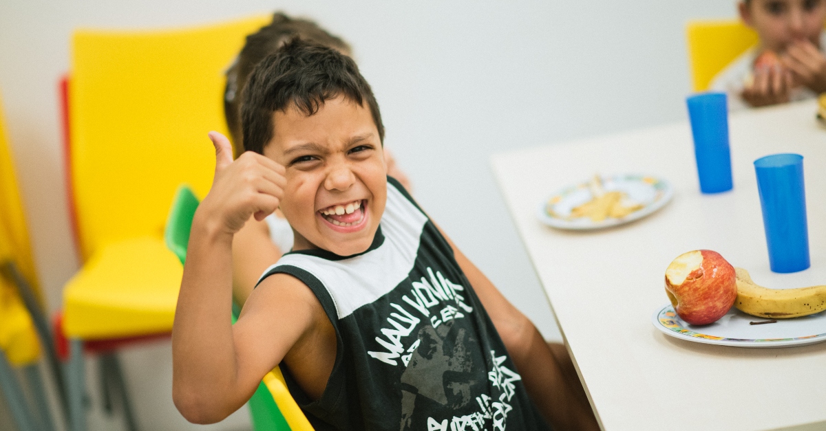 boy smiling at the camera, giving a thumbs up | nonprofit newsletter