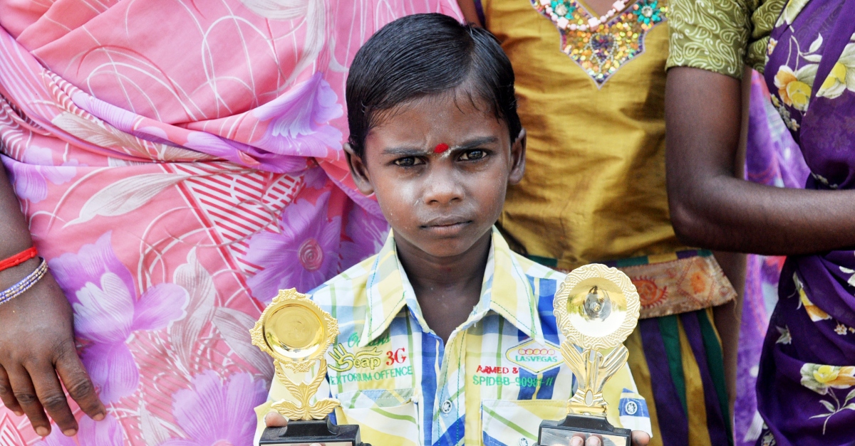 Child holding two trophies. Trust Indicators