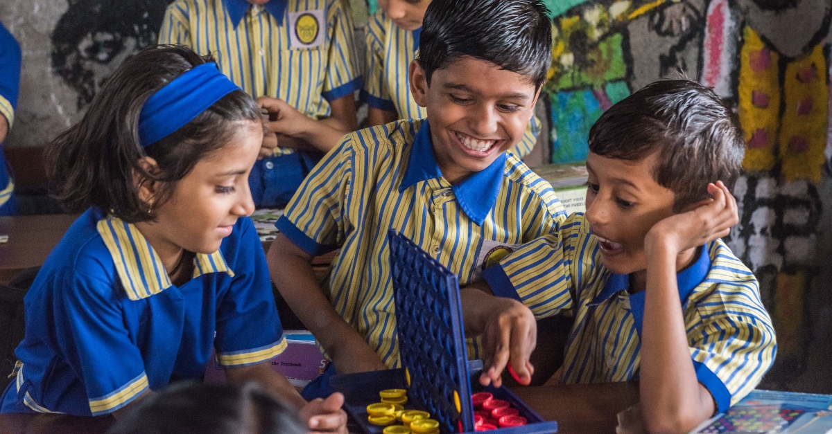 A group of children laughing and playing a game together. Giving decisions