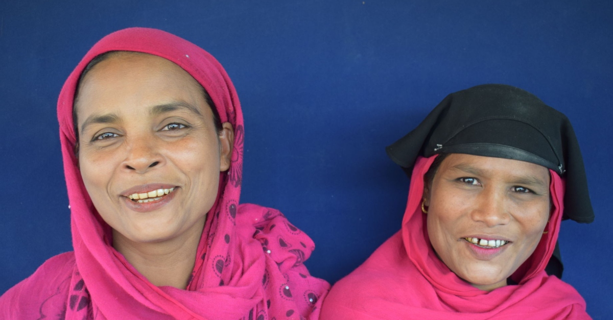 refugees covid-19. two female refugees smiling proudly