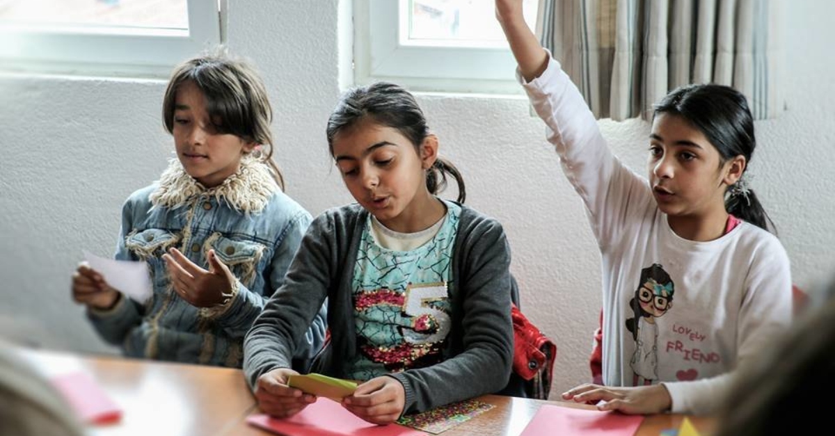 three children sitting at a classroom desk. nonprofit storytelling