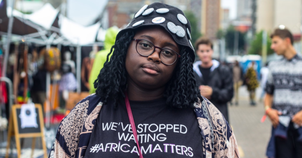 A woman in a black T-shirt that says "We've stopped waiting. #AfricaMatters"