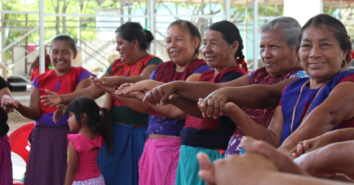 women hold hands in a circle filantropía-liderada-por-la-comunidad