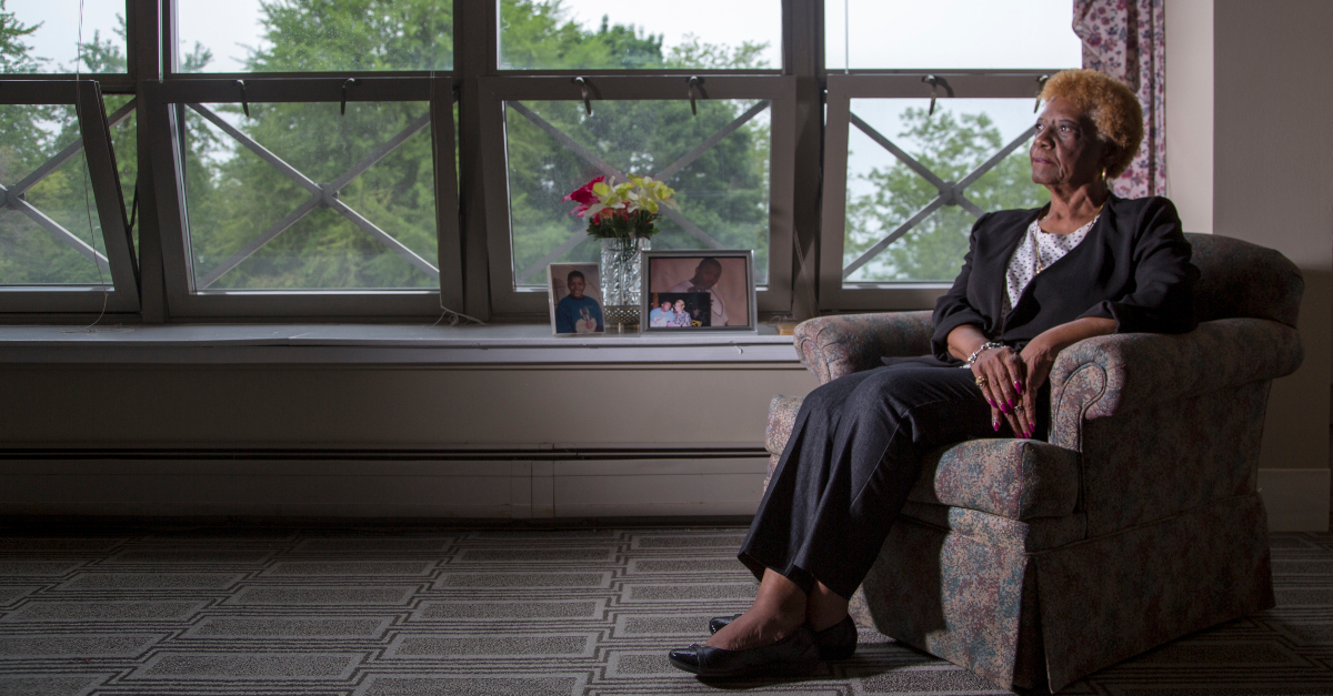 a woman who is one of the voices of gun violence that unsilence works with sits in a chair near a window