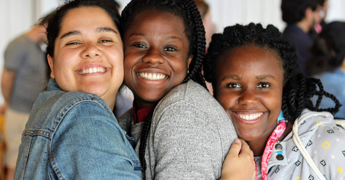 random act of kindness. Three people embracing each other and smiling