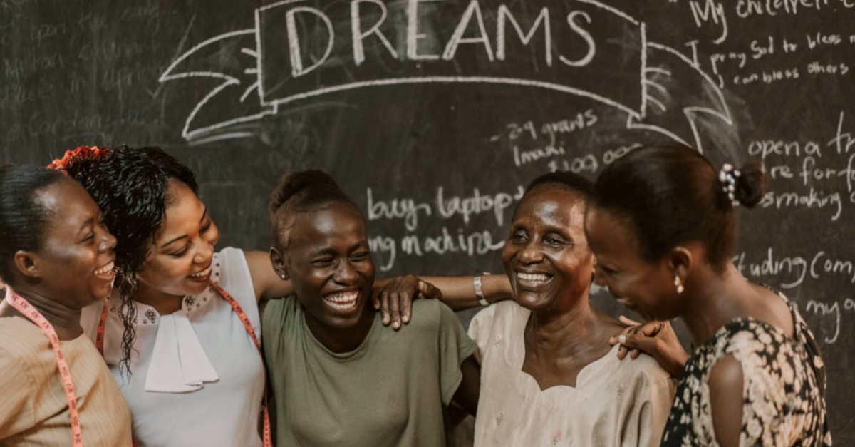 globalgiving raised $105 million. Five women standing with their arms around one another and laughing