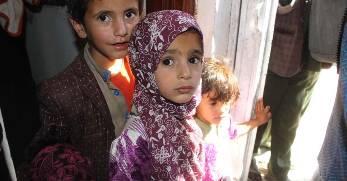 Young children affected by the Yemen crisis stand in a doorway