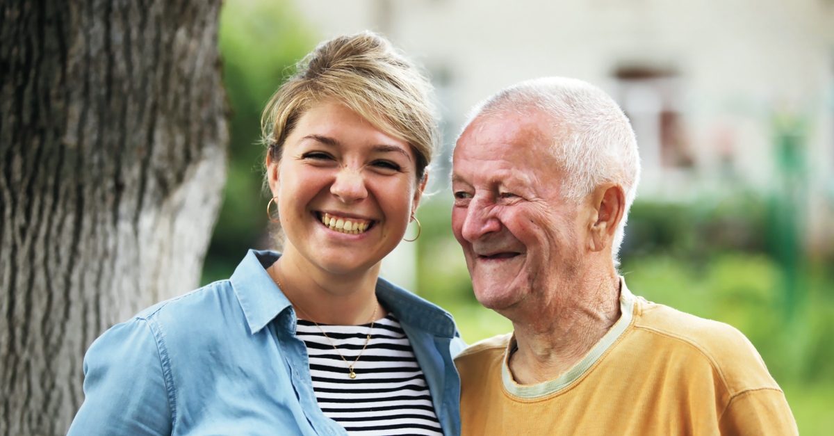 A woman in a black and white striped shirt smiles as she embraces an elderly man in a yellow shirt. creative Father’s Day gift