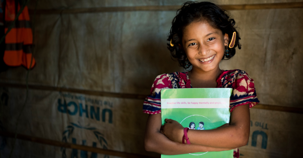 Smiling girl holds a book.