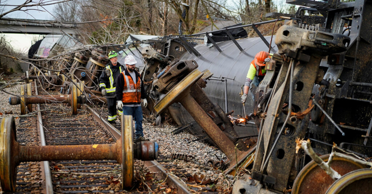 People work at the scene of a train derailment