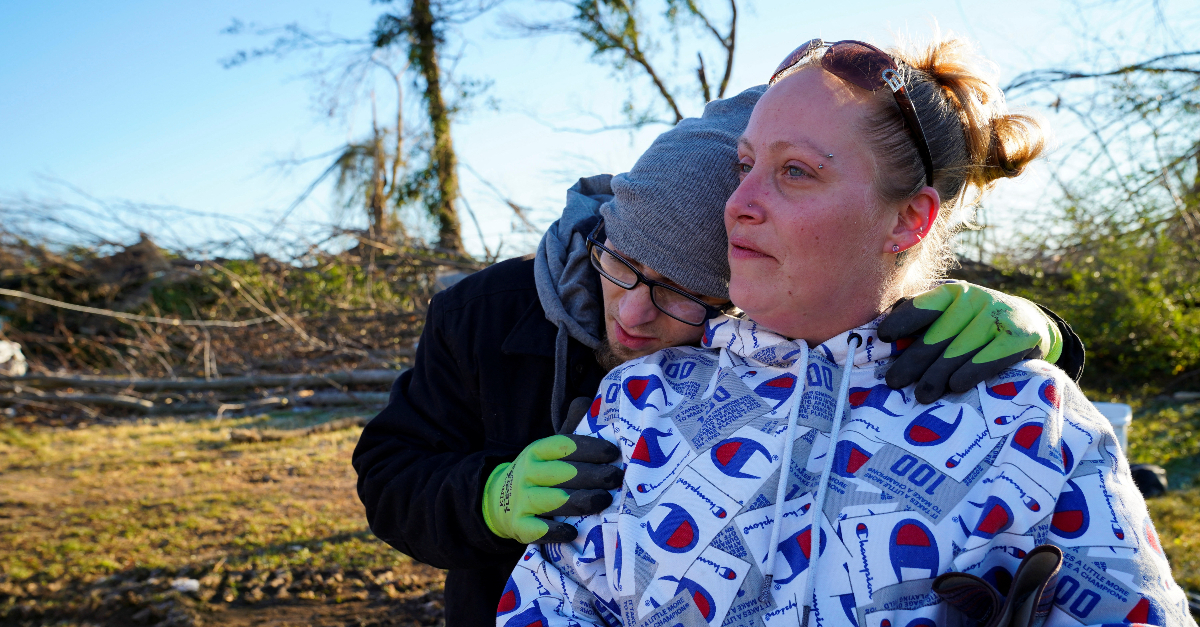 A couple looks out at the pile of debris where their home once stood in the aftermath of a tornado in Mayfield, Kentucky
