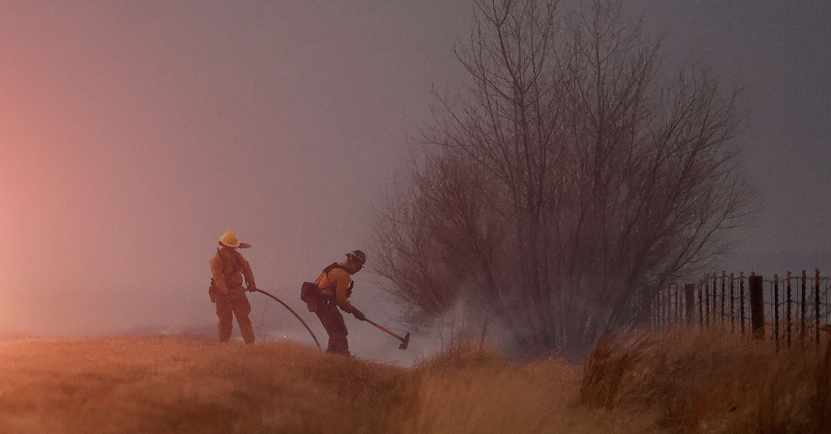 Two firefighters battle the Colorado wildfire amid thick smoke