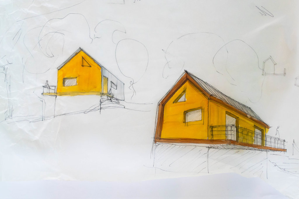 Two yellow houses are sketched onto white paper