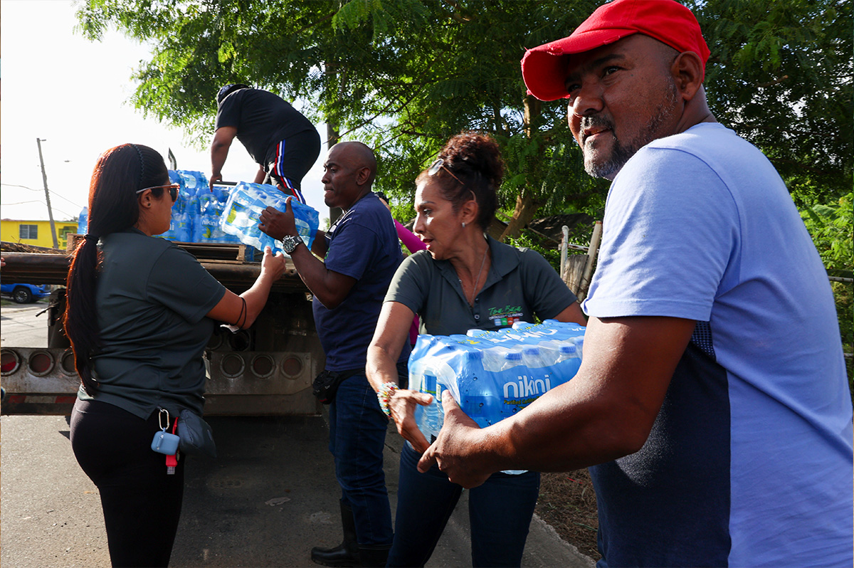 A group of people unloading bottled water.