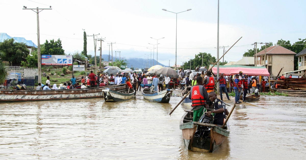 People stranded by the Nigeria floods wait for boats to transport them