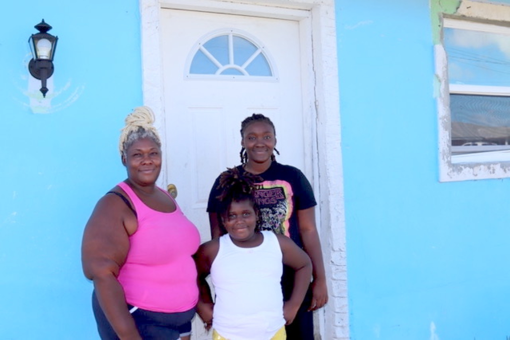 Family stands at their front door after hurricane dorian