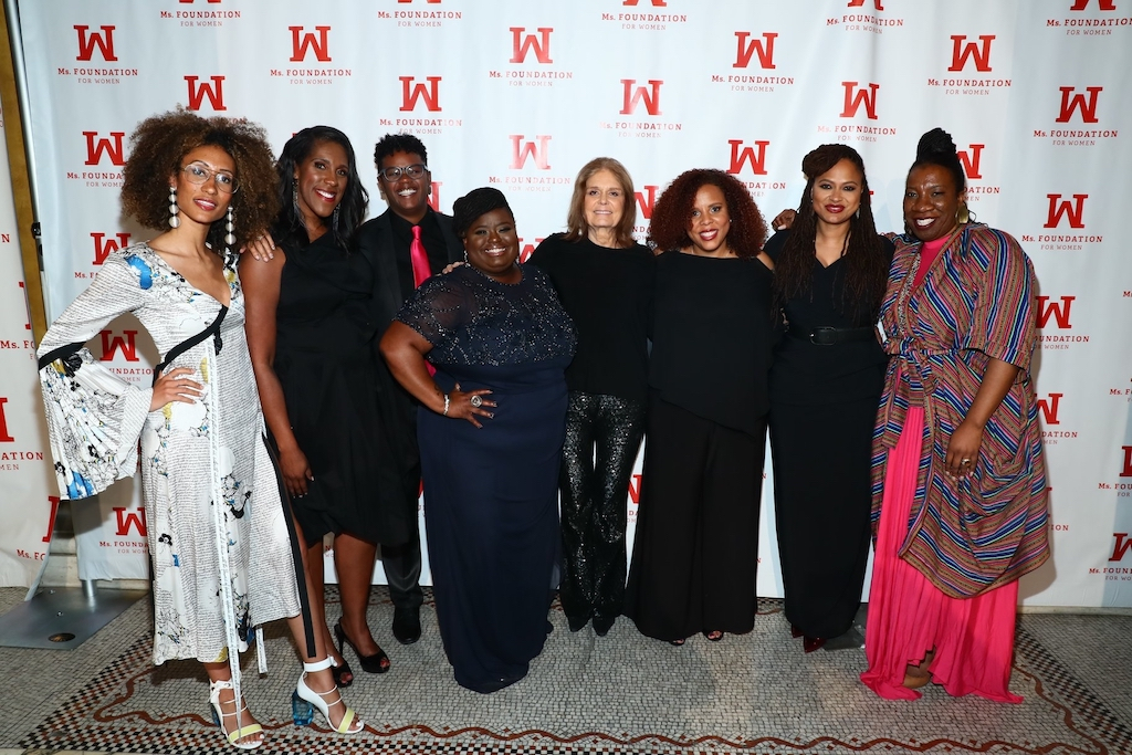 A group of women from Ms. Foundation for Women stand with Gloria Steinem in front of a red and white backdrop black-led nonprofits