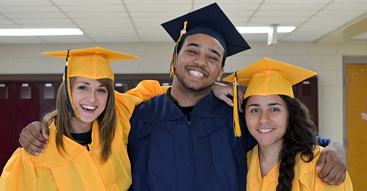 Three students pose together with their graduation caps. unique graduation gift