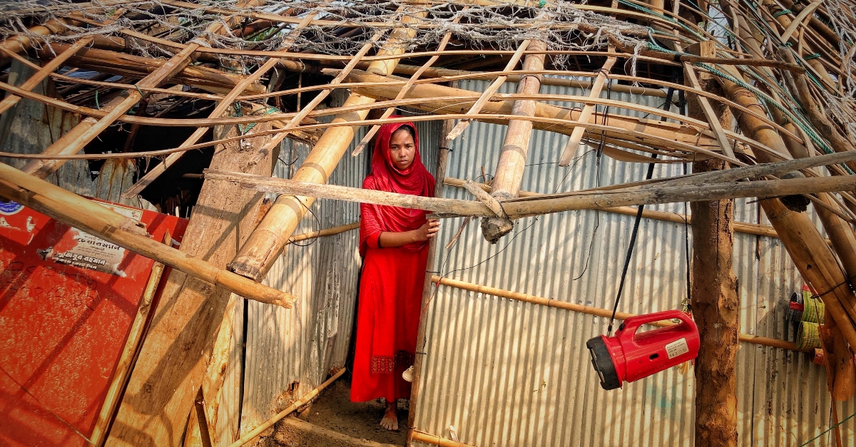 A woman stands in the wreck of a home destroyed by Cyclone Mocha