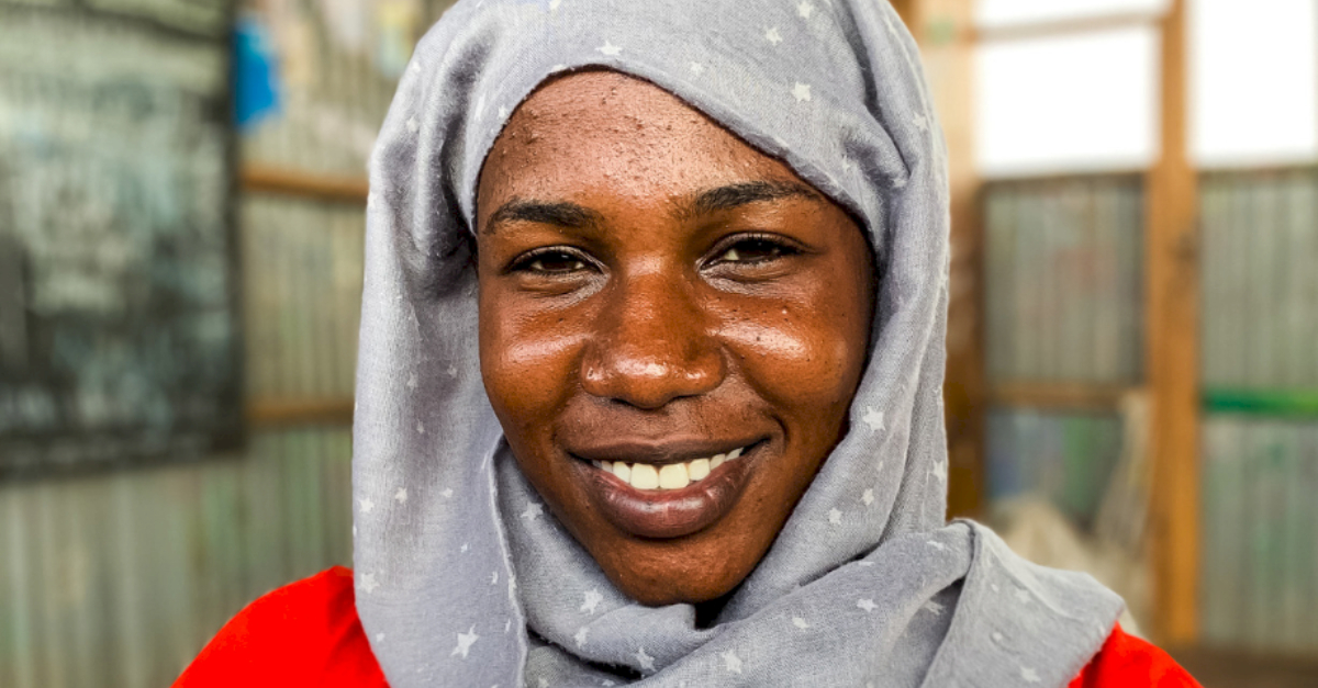 woman in grey hijab smiles at the camera refugee quotes