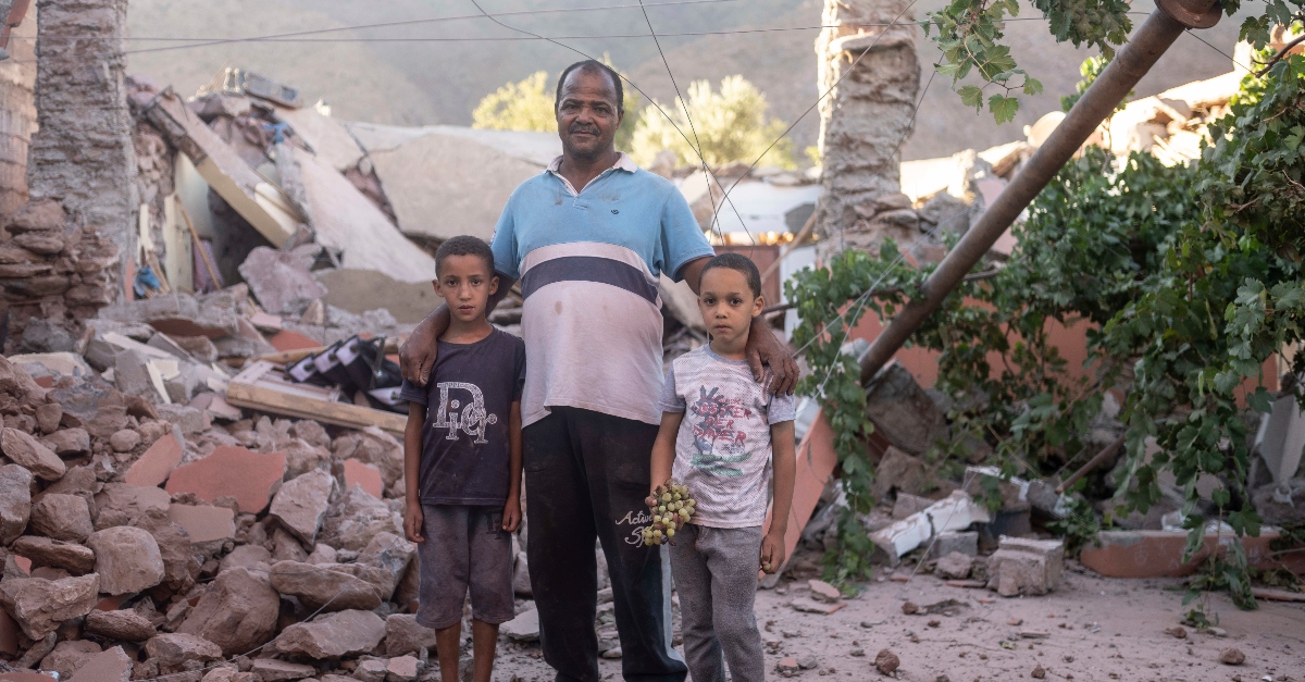 A man and his sons stand amidst the rubble of their home which was damaged by the earthquake, in Ijjoukak village, near Marrakesh, Morocco, Saturday, Sept. 9, 2023
