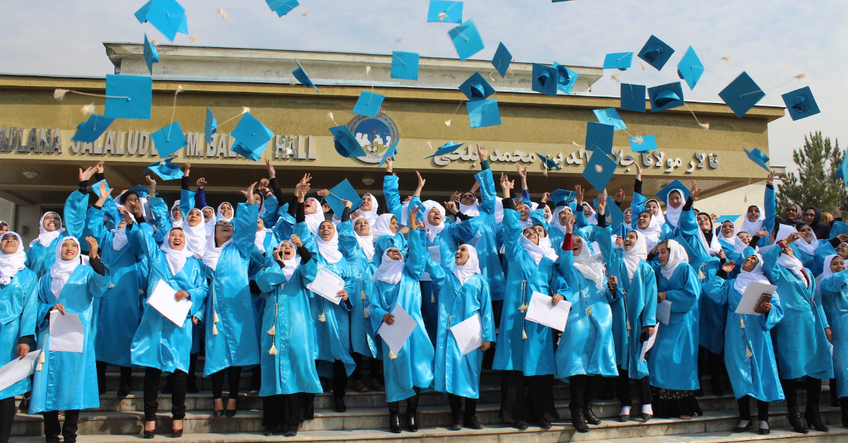 education is the key for Afghanistan a crowd of women graduates wearing hijabs throw their graduation caps in the air