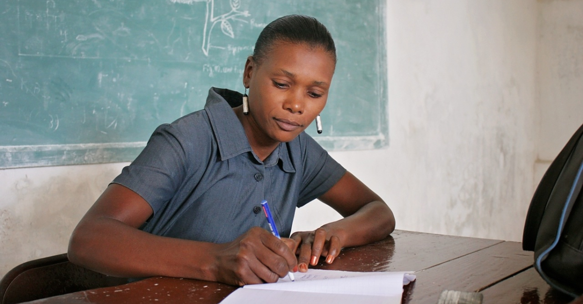 woman sits at desk, writing in notebook ESG philanthropy reporting