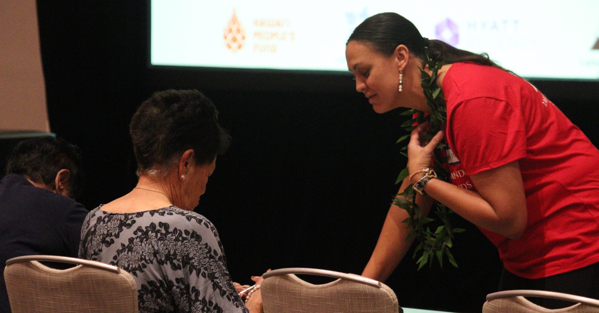 A Lahaina Community Land Trust member speaks with a community member post wildfire.