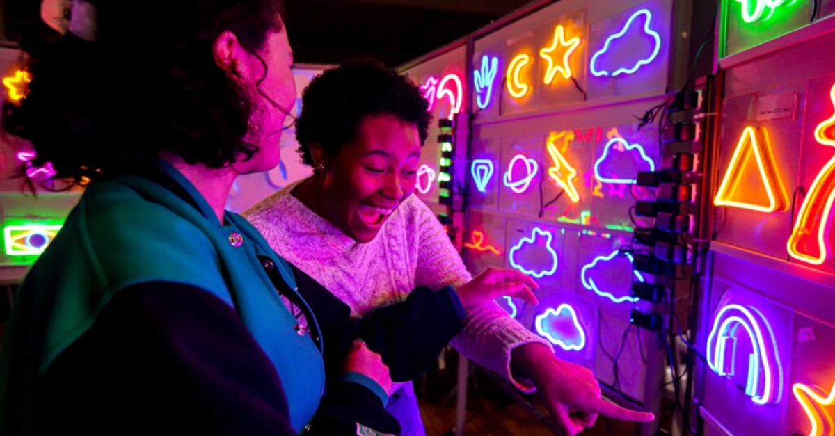 Two young people playing a game in an arcade
