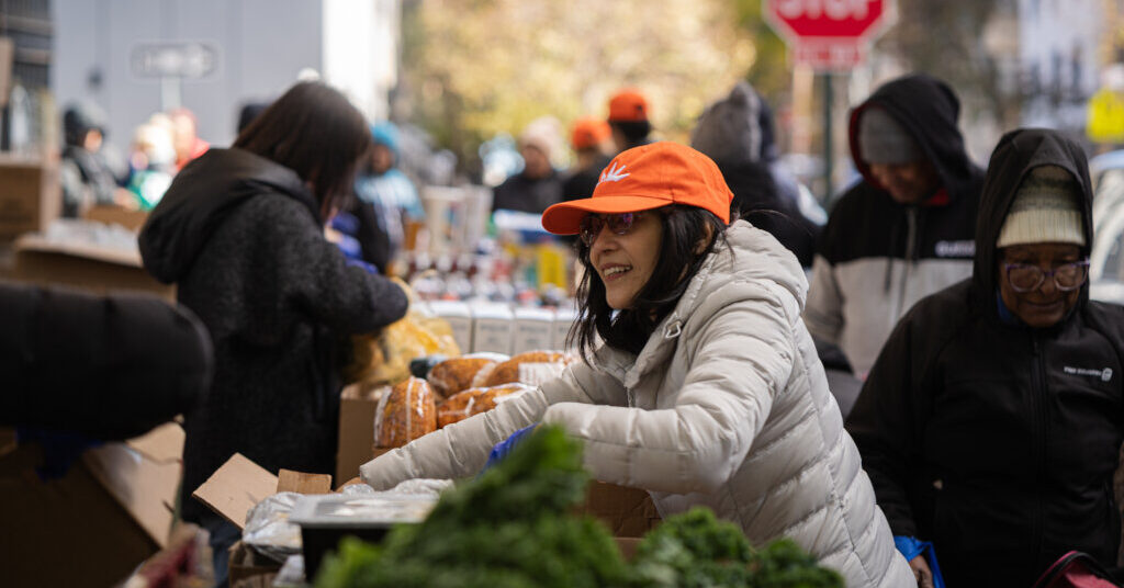 A woman working at a food pantry on a city street