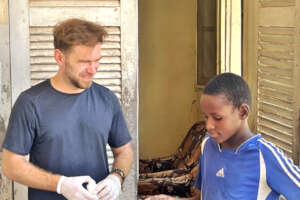 Maxim gives a talibe child medication in a daara