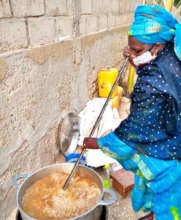 A neighborhood "Godmother" preparing the meal