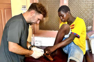 Treating a talibe youth's wound in the infirmary