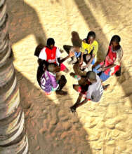 Talibe children relax on the clean sand.