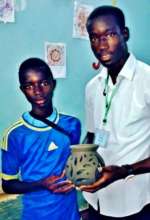 A volunteer and his student with pottery creation