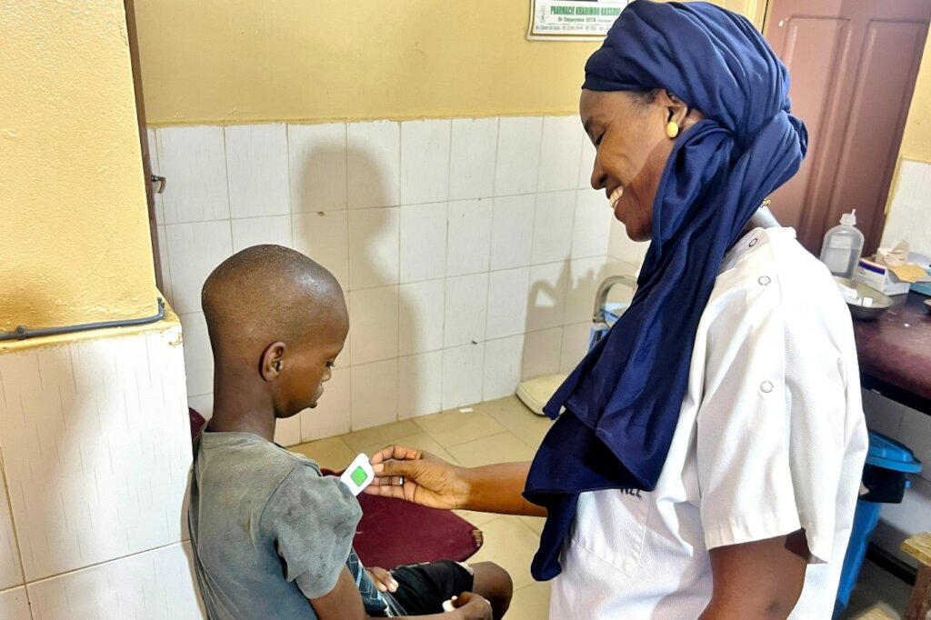Awa reassures a talibe, taking his temperature