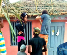 Volunteers repair the library's thatched roof