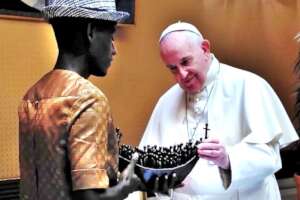 Arouna presents a sculpture to Pope Francis