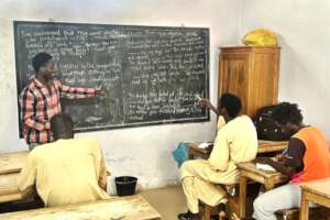 Peter teaching English to older talibes