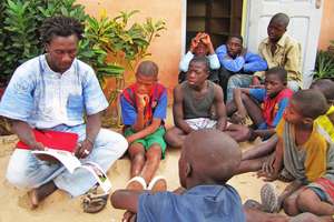 Issa reading to talibe children by MDG library