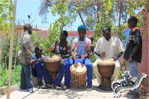 Older talibes relax playing djembe