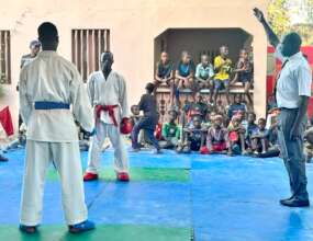 A referee signals for combat to begin.