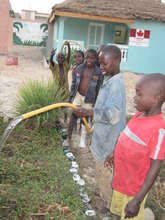 Talibes watering garden, in front of new infirmary